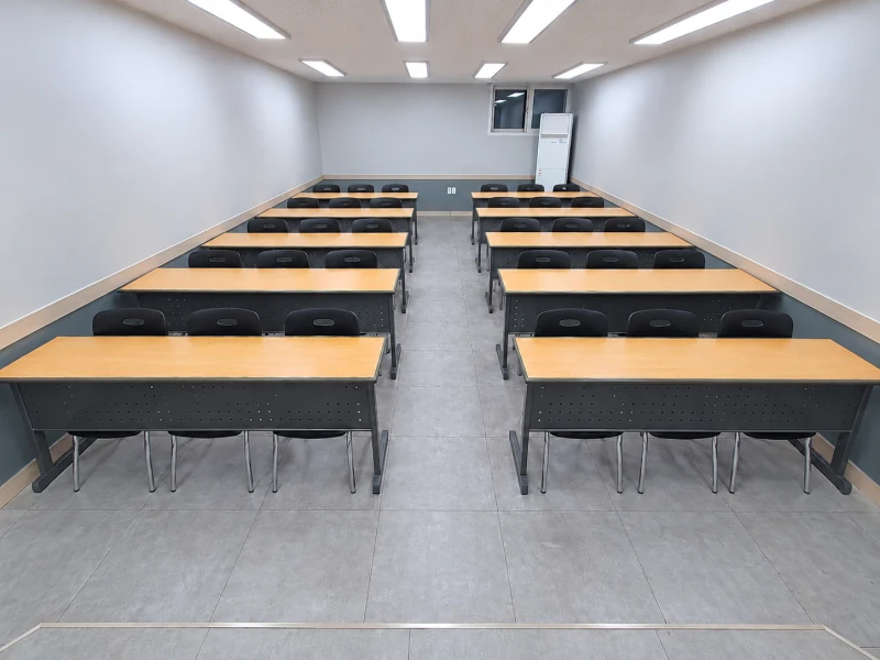 1번룸 — 강의형 책상 배치와 중앙 통로, 창문과 냉난방기가 있는 뒤쪽 전경